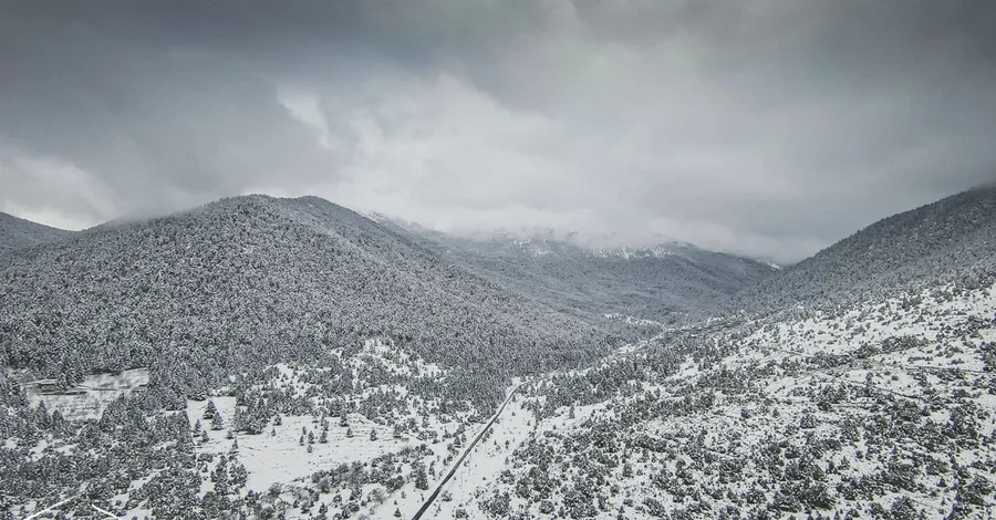 A snowy valley with a road, from above