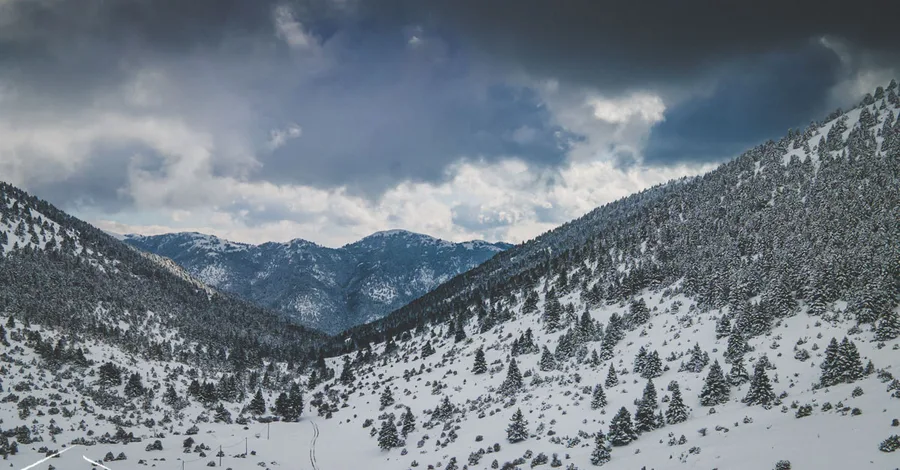 A snow-covered valley under a dramatic sky