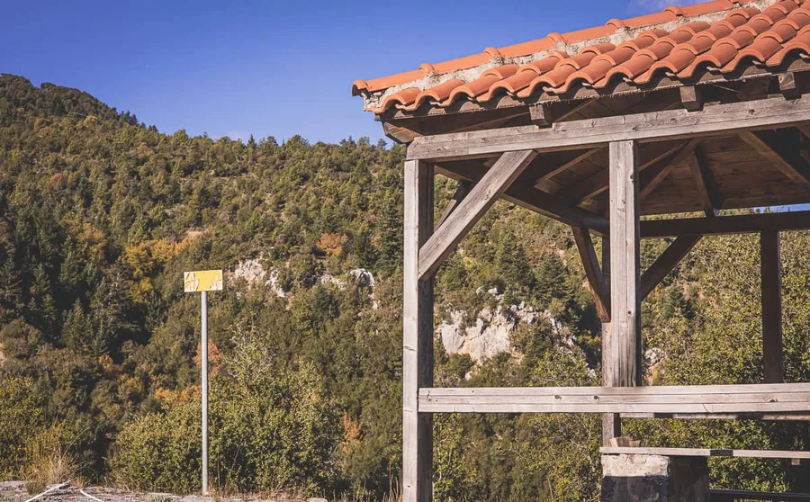 A timber shelter with a tiled roof beside the path
