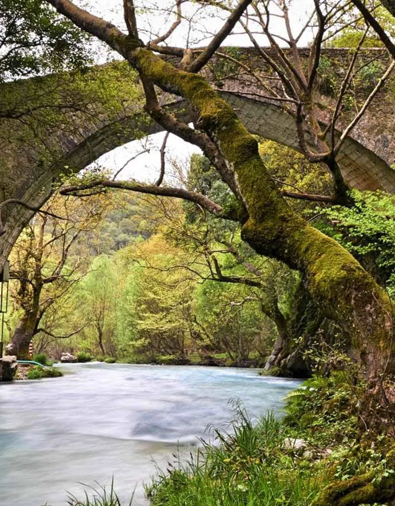 The arch of a stone bridge over the river