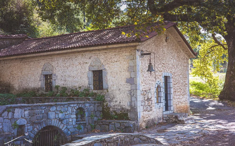A small stone church beside a stone bridge
