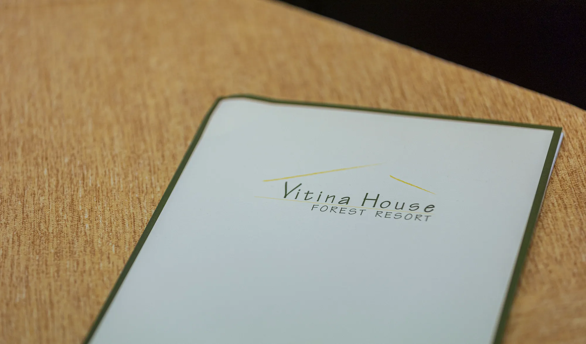 A notepad with the Vitina House Forest Resort logo on a table