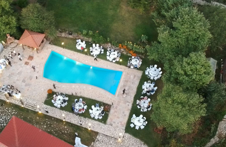 Το κτήμα από ψηλά με τραπέζια στρωμένα γύρω από την πισίνα