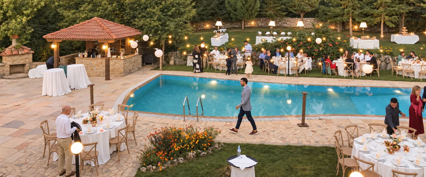 Guests at the tables and around the pool at dusk, with the gazebo bar and string lights