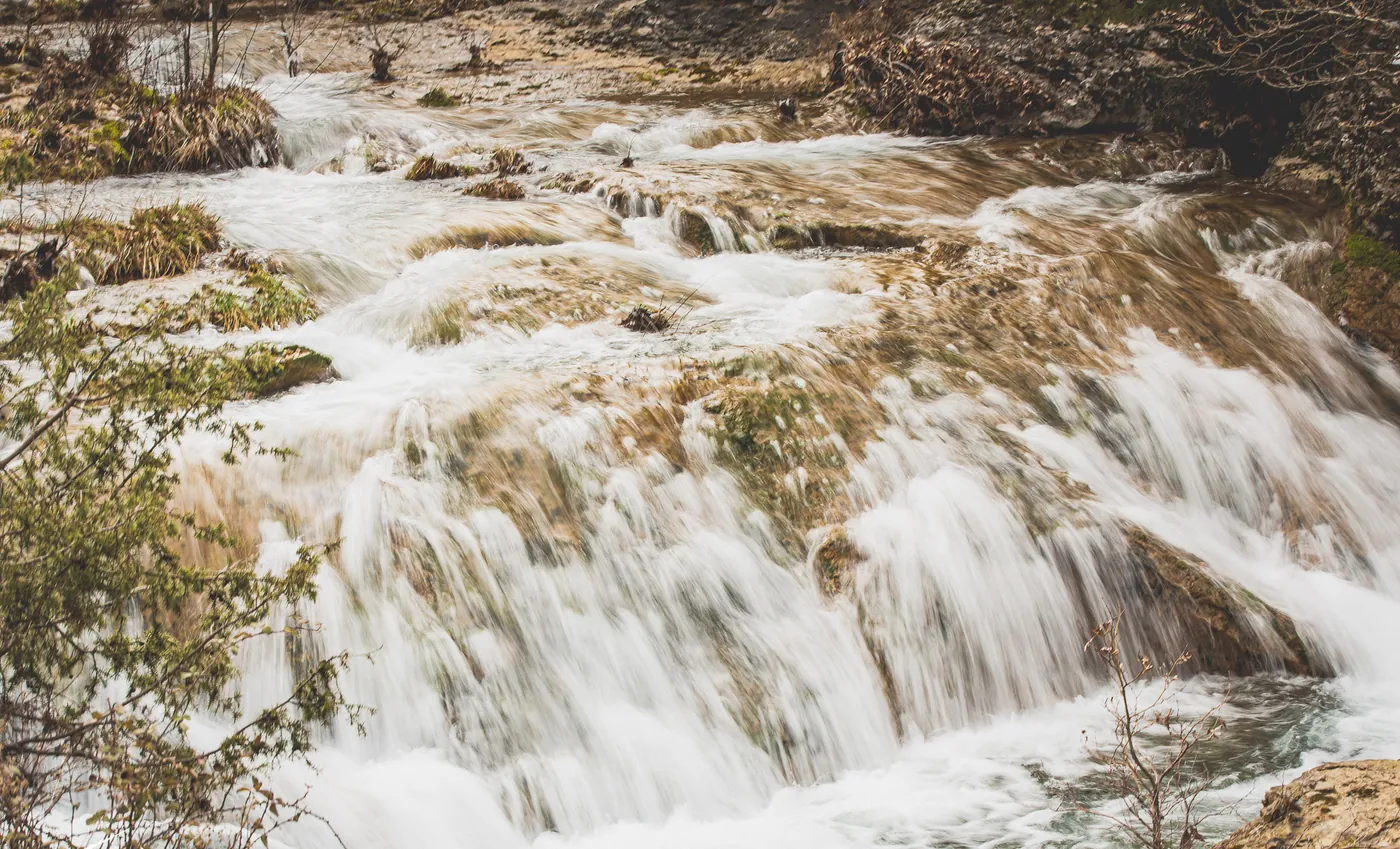 A white cascade of meltwater over mossy rocks in a Menalo stream