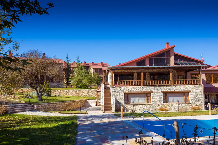 Κτίριο με κόκκινη στέγη δίπλα στην πισίνα σε καθαρή μέρα
