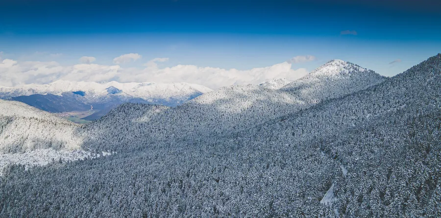 A snow-covered valley below the peaks