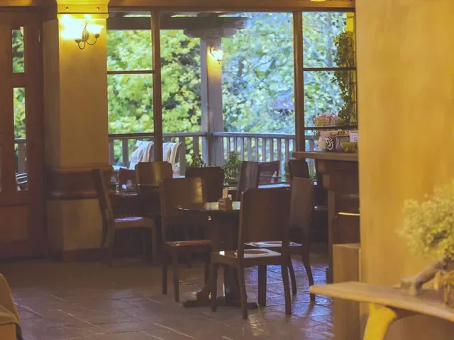 Τραπέζια του εστιατορίου δίπλα στα παράθυρα του κήπου, στρωμένα για πρωινό