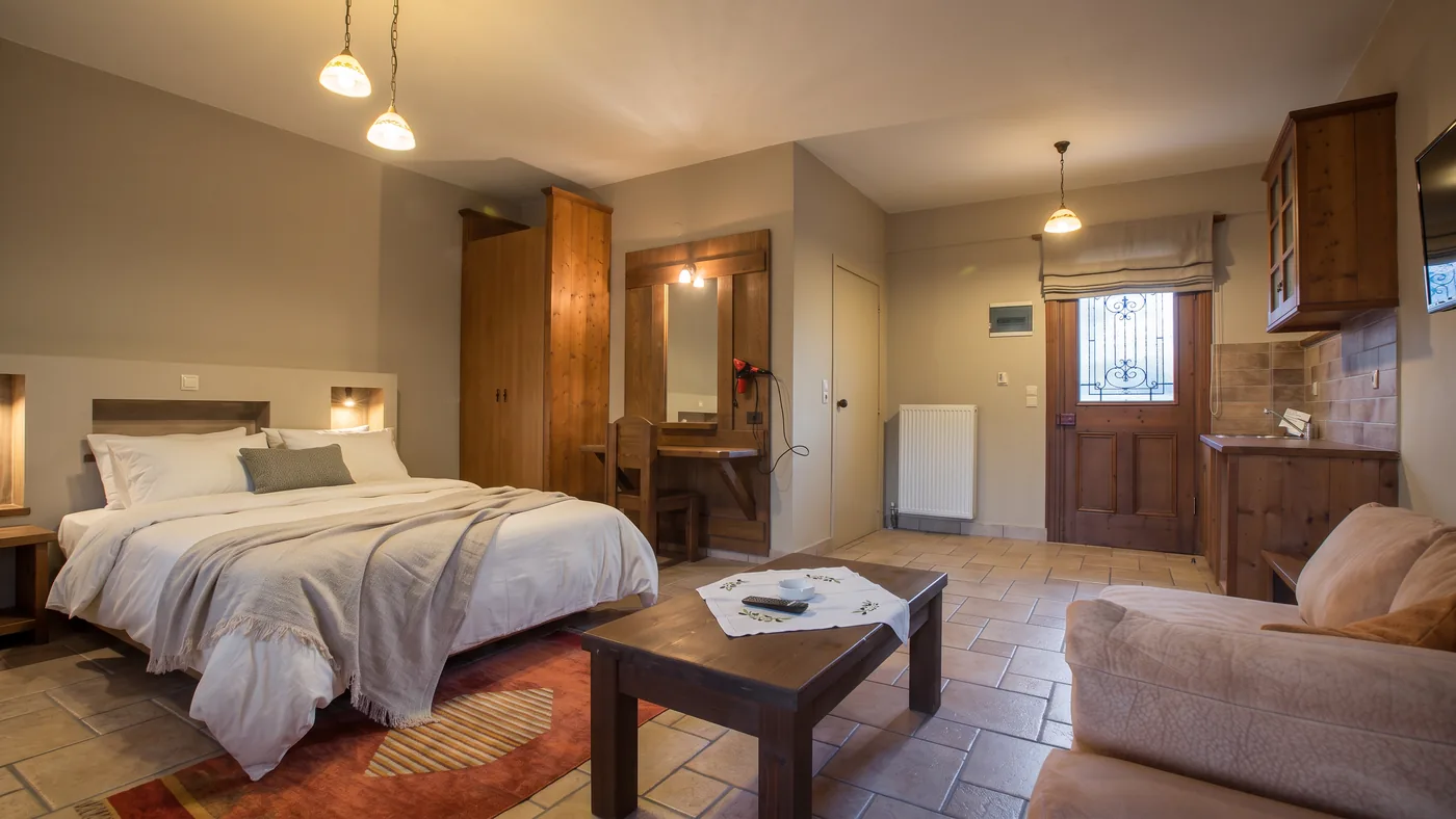 Standard room seen from the sofa corner towards the bed, wardrobe, dressing table and entrance